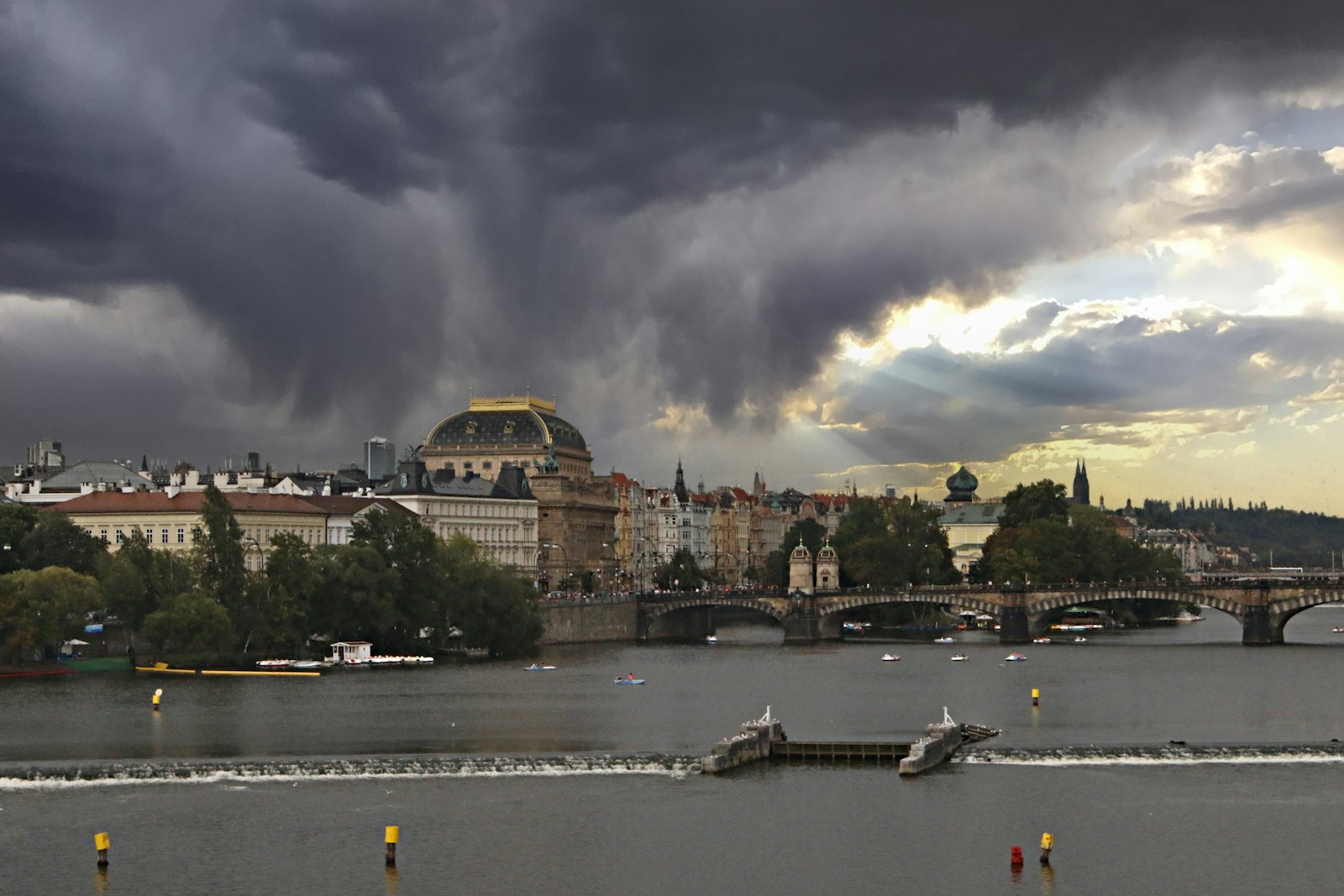 Storm clouds gathering over a city skyline and river