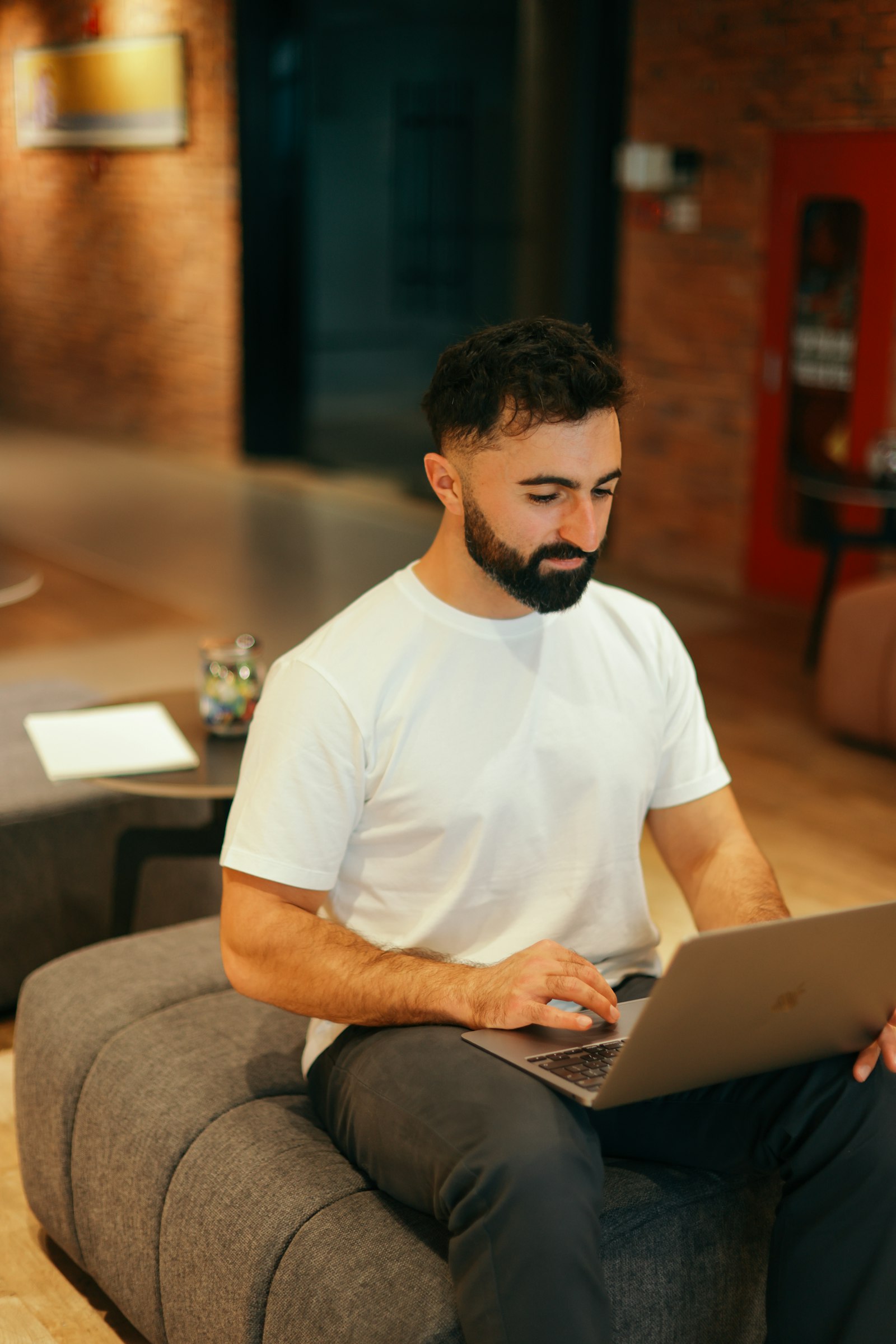 Man working on a laptop in a modern office lounge