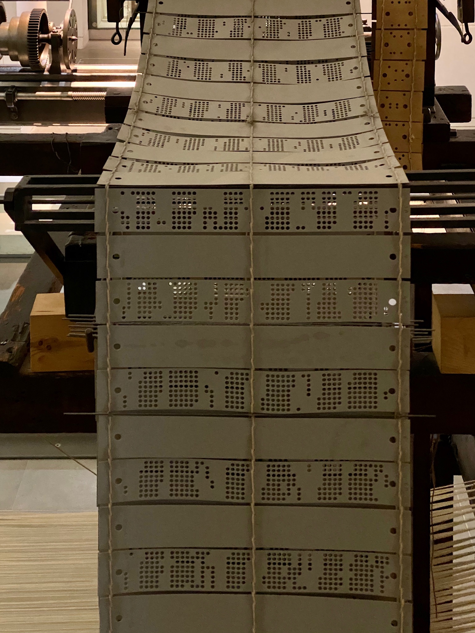 Jacquard loom punch cards hanging from a historical machine