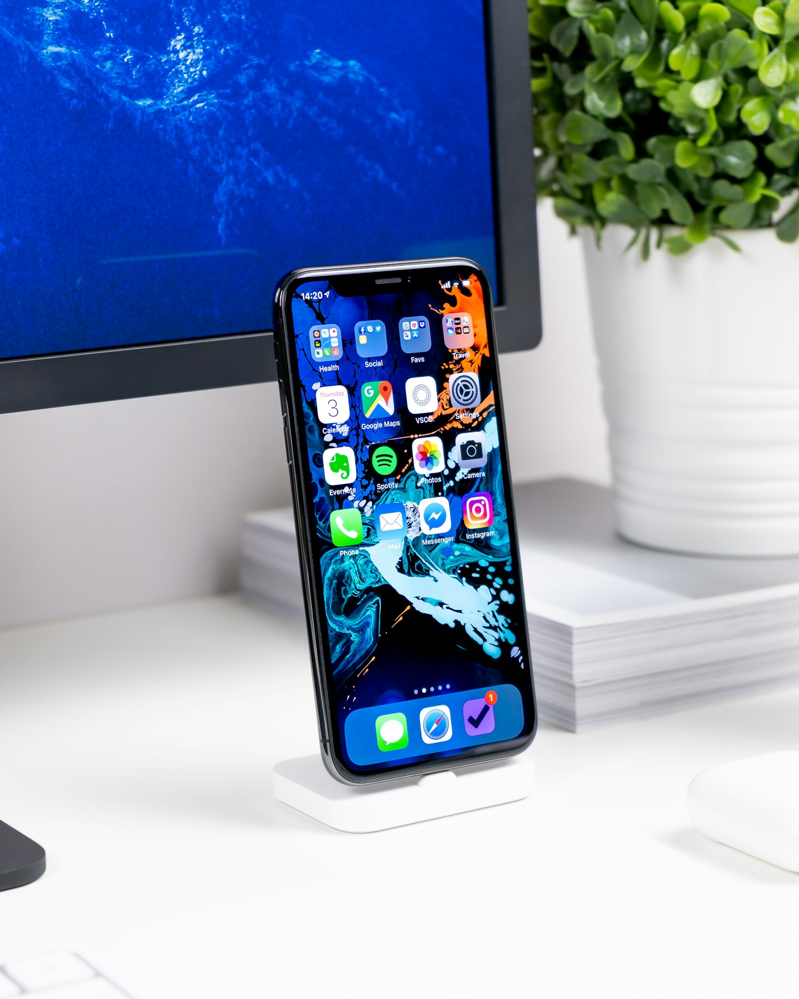 Minimal desk setup with smartphone, laptop, and accessories