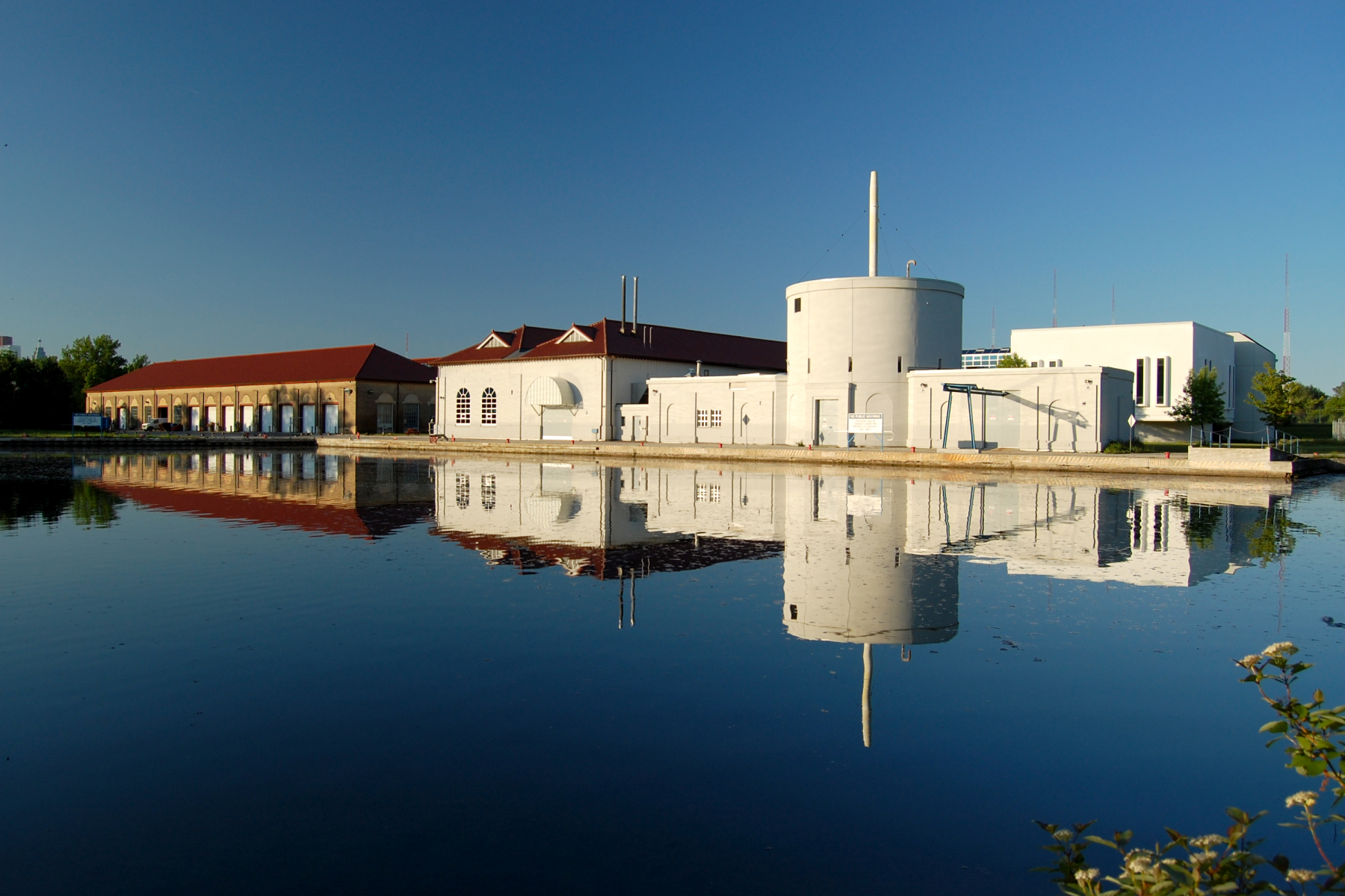 Water treatment plant buildings reflected in still water